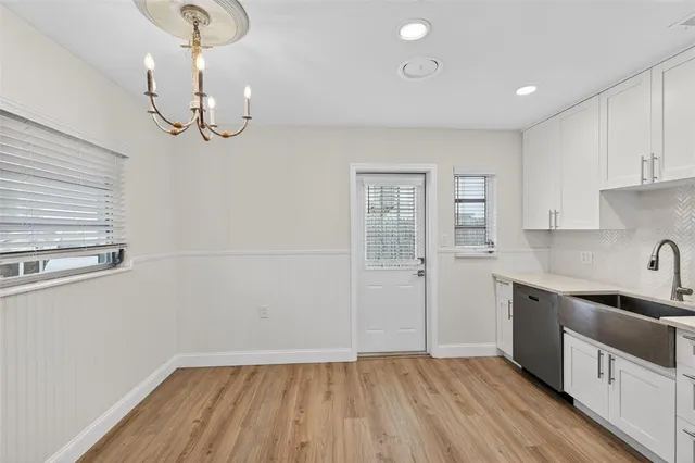 a kitchen with cabinets a sink dishwasher and a stove with wooden floor