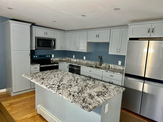 a kitchen with stainless steel appliances granite countertop a sink stove and refrigerator