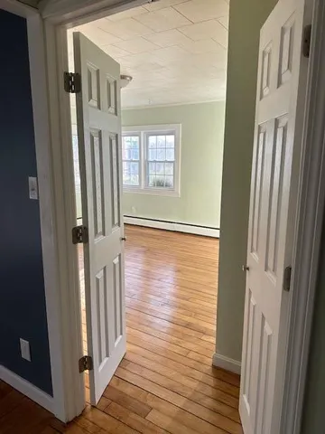 a view of a hallway with wooden floor and staircase