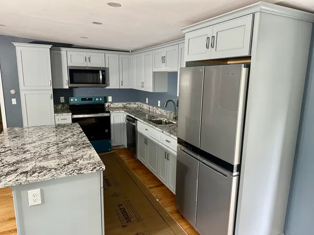 a kitchen with white cabinets and stainless steel appliances