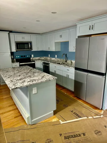 a kitchen with stainless steel appliances granite countertop a sink stove and refrigerator