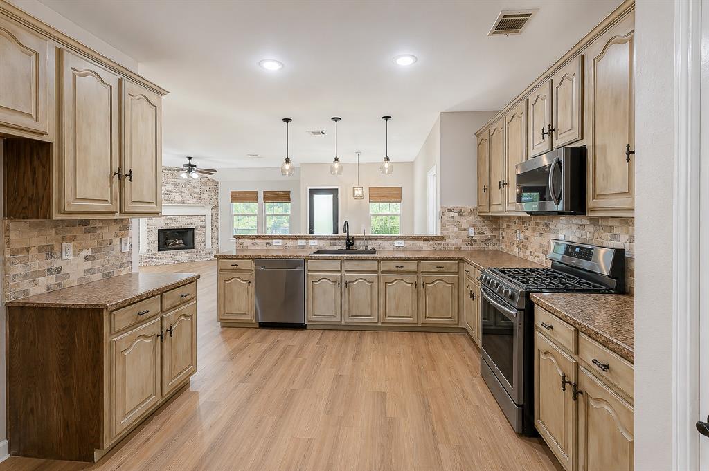 1070 Shepard Lane Lavon, TX 75166 - Photo 12 of 29 a kitchen with stainless steel appliances granite countertop a stove top oven a sink dishwasher and a refrigerator with wooden floor