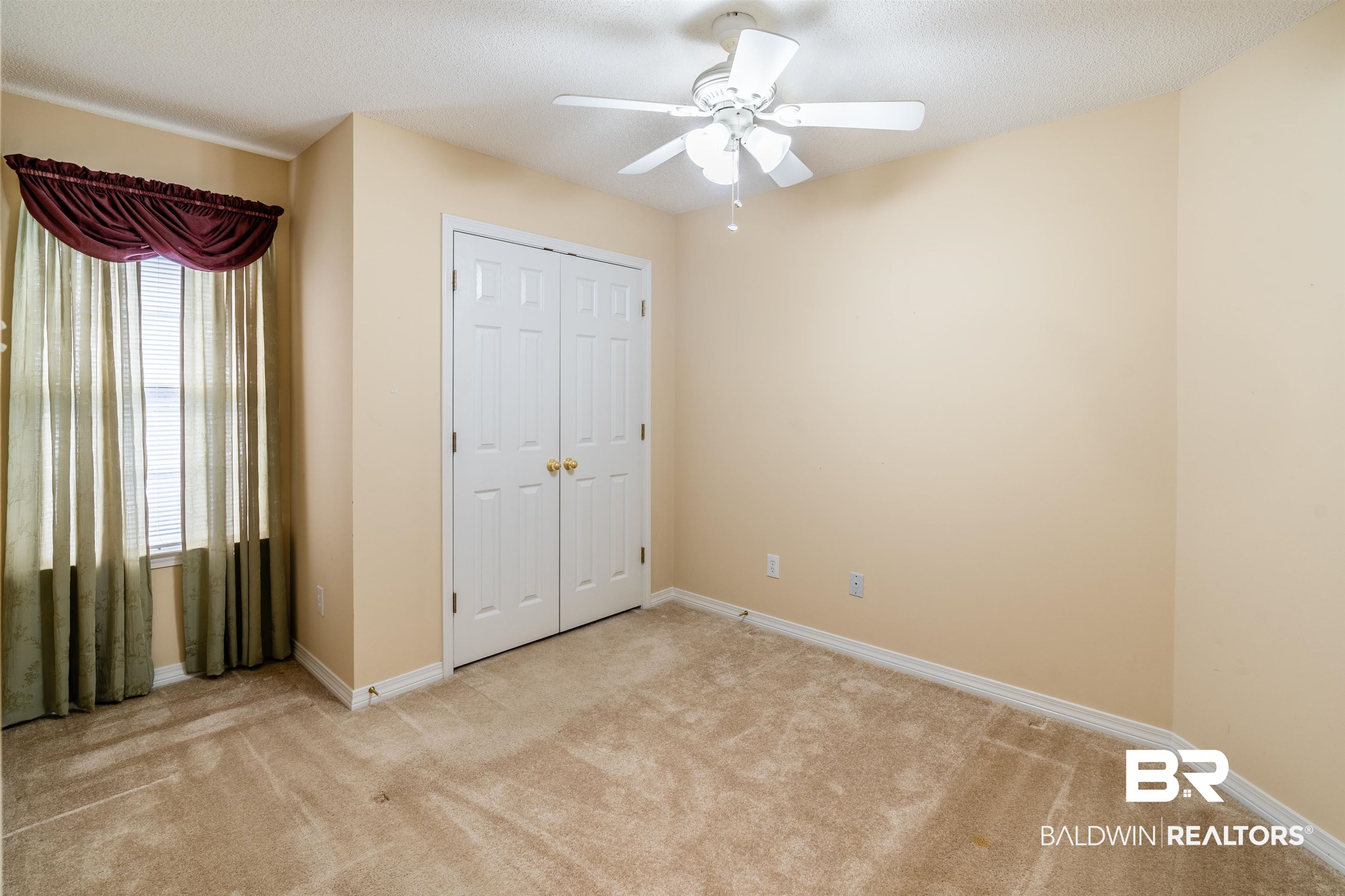 1784 Harrington Way Mobile, AL 36695 - Photo 14 of 18 Unfurnished bedroom with a textured ceiling, light carpet, ceiling fan, and a closet