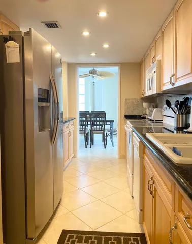 a kitchen with stainless steel appliances granite countertop a refrigerator and a stove