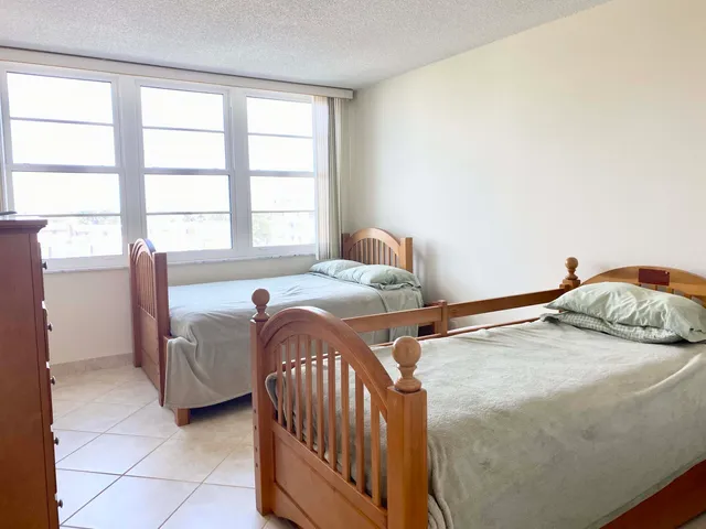 a bedroom with two beds and a large window