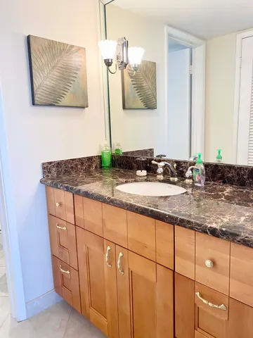 a bathroom with a granite countertop sink and a mirror
