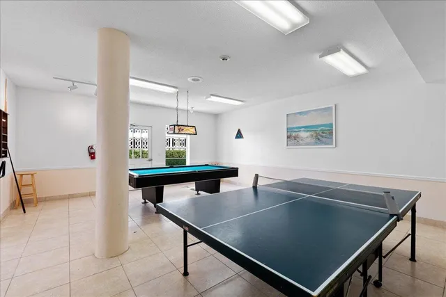 a room with pool table and windows