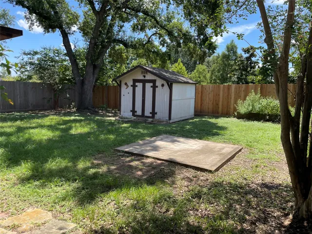 a view of a house with backyard and tree