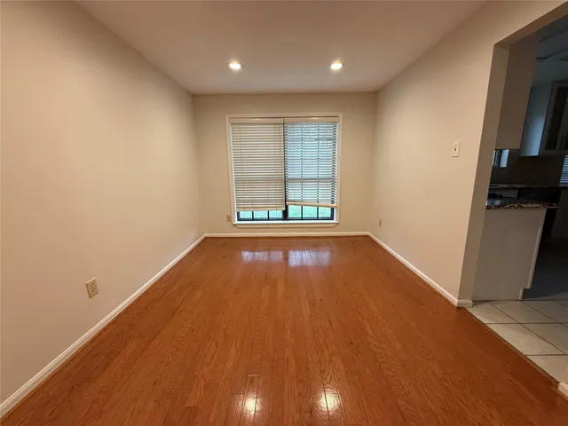 an empty room with wooden floor and a window