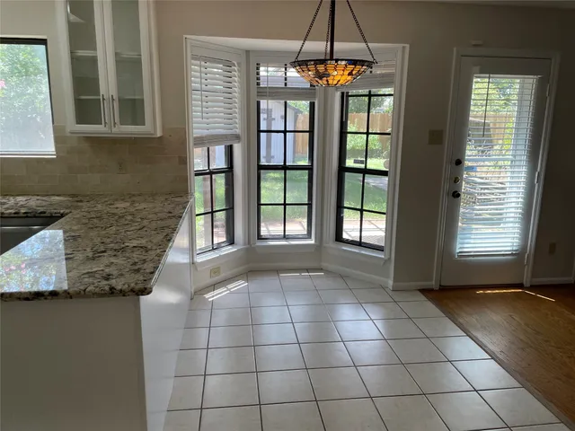 an empty room with wooden floor fireplace and windows