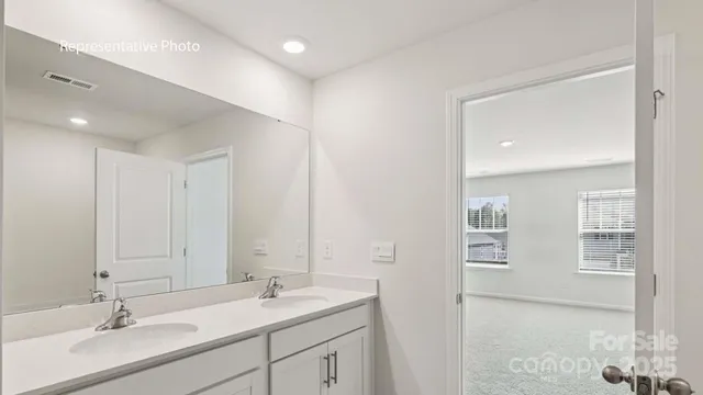 a bathroom with double vanity sinks and a mirror