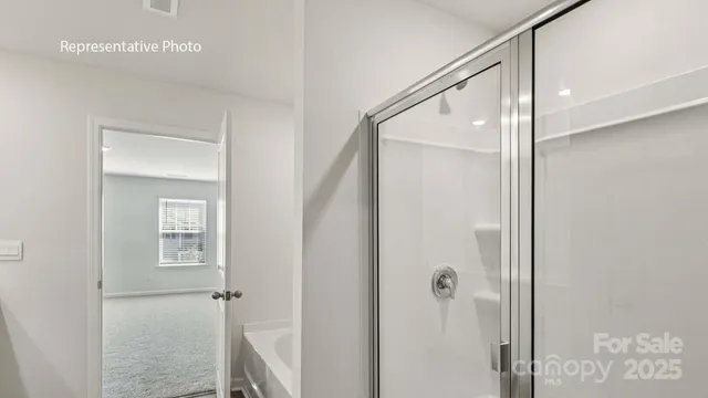 a bathroom with a glass shower door and mirror
