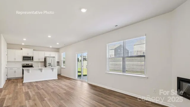 a view of a kitchen with furniture and wooden floor