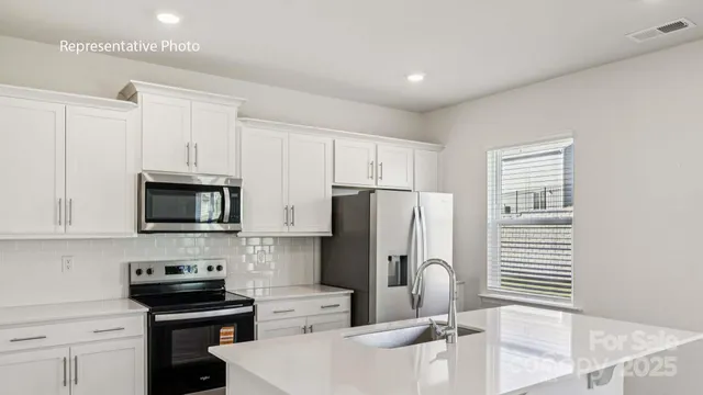 a kitchen with stainless steel appliances a stove a sink a microwave and cabinets