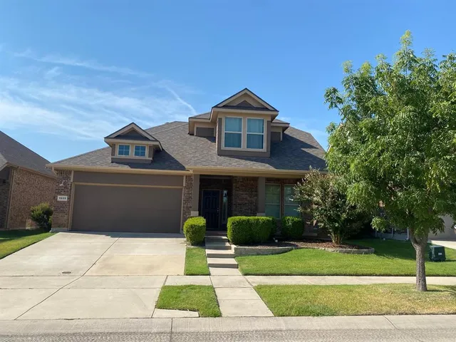 a front view of a house with a yard and potted plants