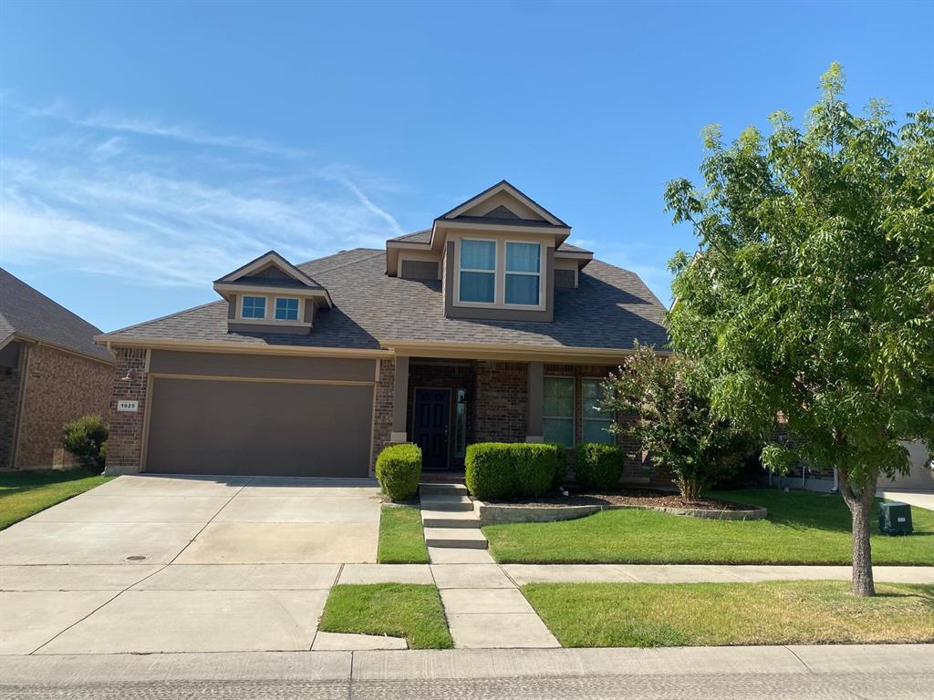 a front view of a house with a yard and potted plants