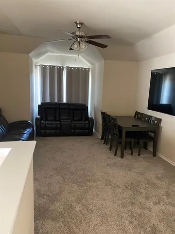 a living room with furniture a ceiling fan and a window