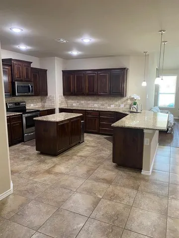 a kitchen with stainless steel appliances granite countertop a sink counter space cabinets and a window