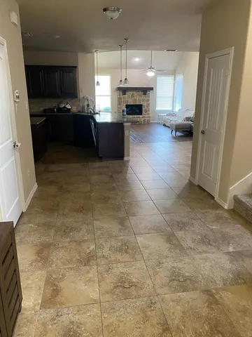 a kitchen with kitchen island granite countertop a refrigerator and a stove top oven