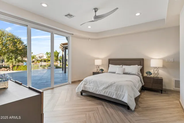 a bedroom with a large bed and a flat tv screen on dresser