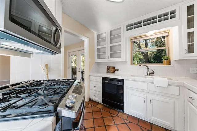 a kitchen with stainless steel appliances granite countertop a refrigerator sink and stove