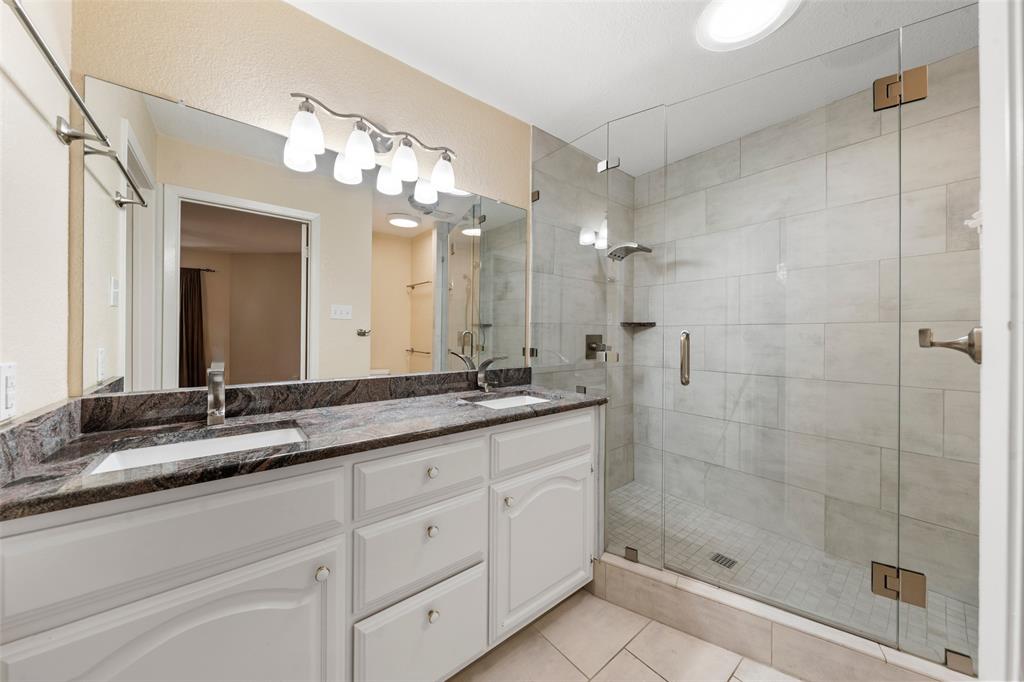 3825 North 30th Street Waco, TX 76708 - Photo 21 of 38 a bathroom with a granite countertop sink mirror and shower