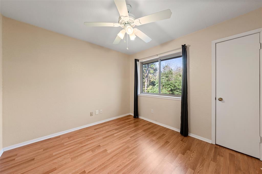 3825 North 30th Street Waco, TX 76708 - Photo 27 of 38 an empty room with wooden floor chandelier fan and windows