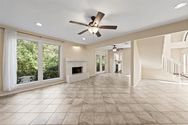 a view of a livingroom with a chandelier fan and windows