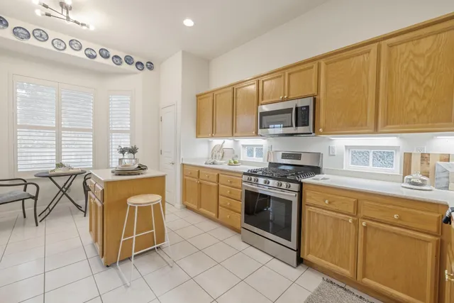 a kitchen with stainless steel appliances granite countertop a stove a sink and a microwave