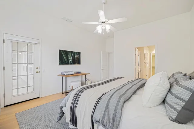 a bedroom with a bed and a flat tv screen on dresser
