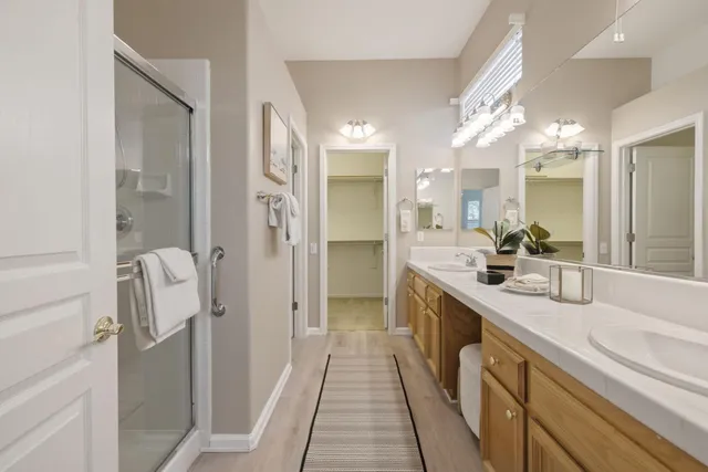 a bathroom with a double vanity sink mirror and shower