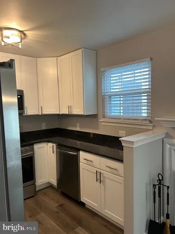 a kitchen with granite countertop white cabinets and white appliances