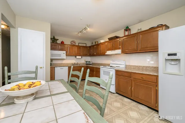 a kitchen with stainless steel appliances granite countertop a sink a stove and a refrigerator