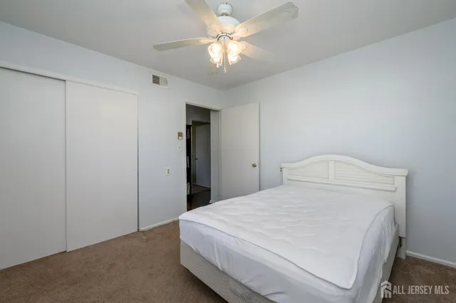 a bedroom with a bed and a chandelier fan