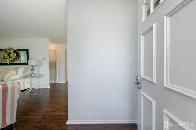 a view of a hallway with wooden floor and a living room