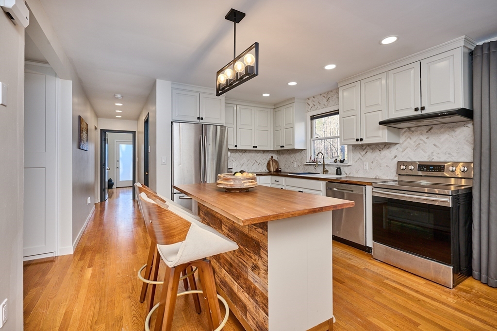 15 Gulf Road Pelham, MA 01002 - Photo 6 of 42 a kitchen with stainless steel appliances granite countertop a sink a stove a refrigerator and island with wooden floor