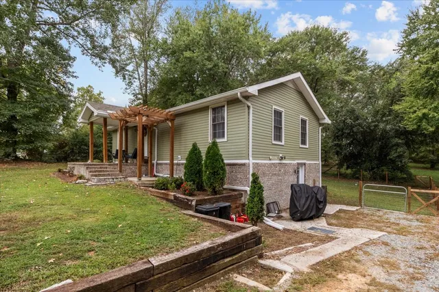 a view of a house with backyard and chairs