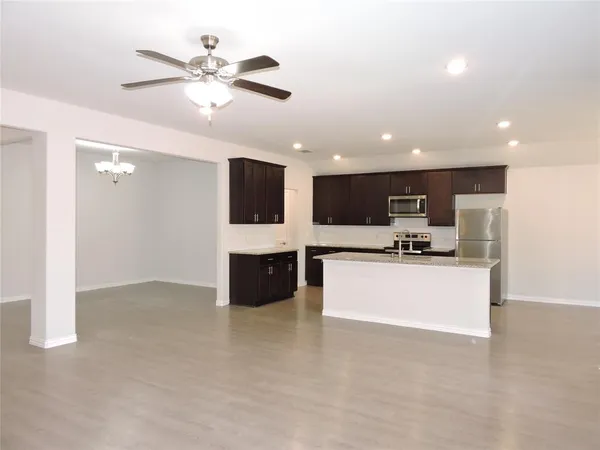 a view of kitchen with kitchen island stainless steel appliances a sink stove and cabinets