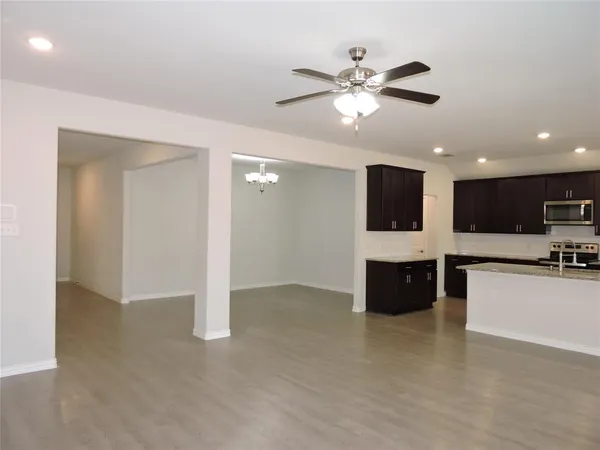 a view of kitchen with refrigerator stove and microwave with wooden floor