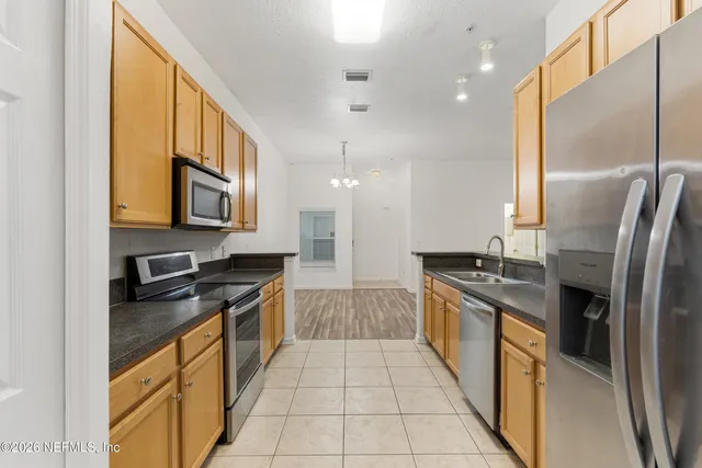 a kitchen with stainless steel appliances granite countertop a sink and a stove