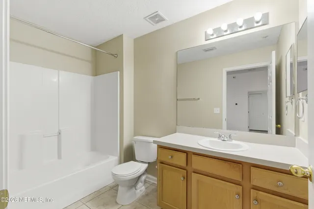 a bathroom with a sink a toilet a mirror and shower