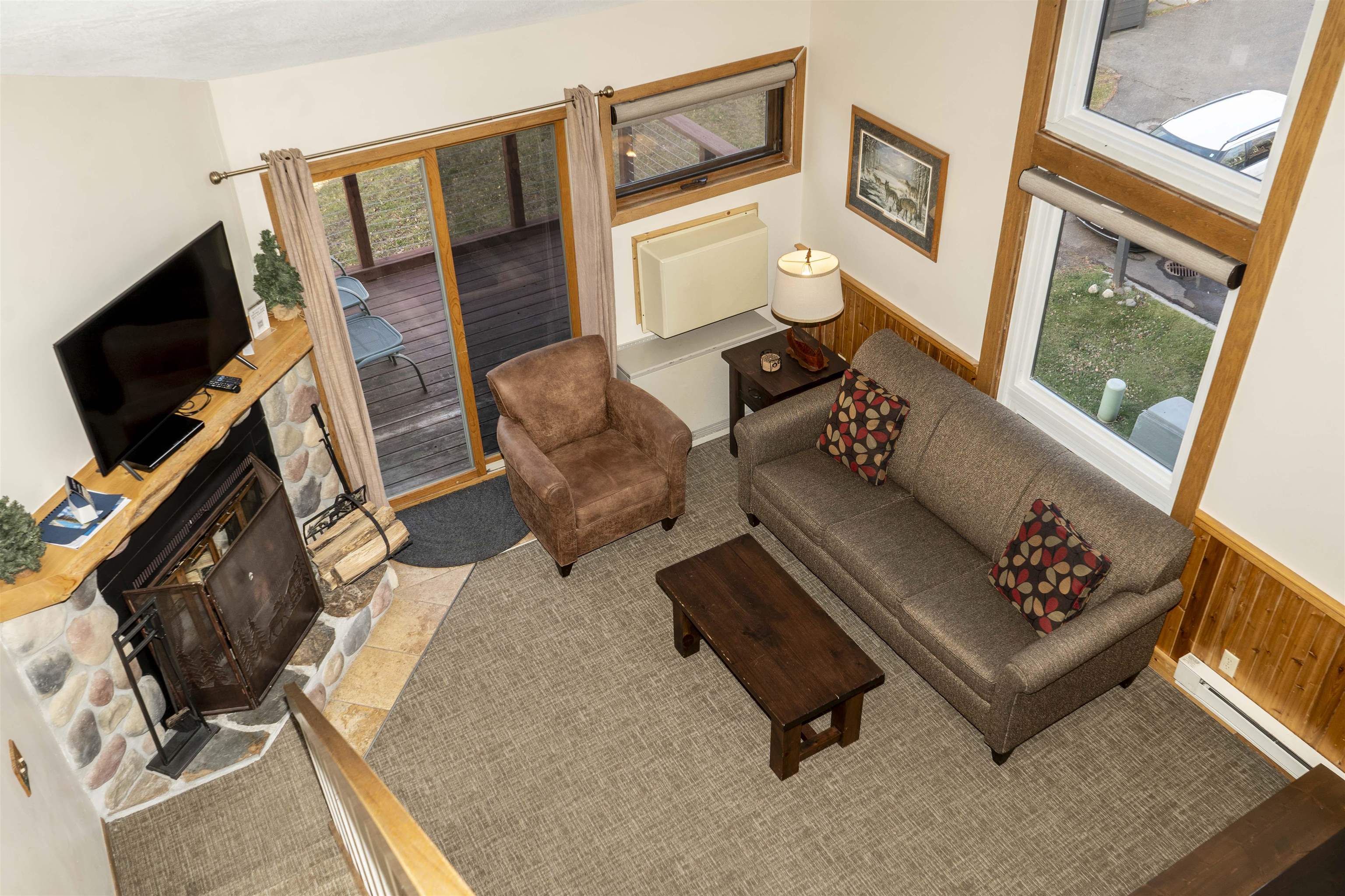 111 Bridge Run Lane, Unit 111 Lutsen, MN 55612 - Photo 14 of 48 Living area with healthy amount of natural light, baseboard heating, a fireplace, and a wainscoted wall