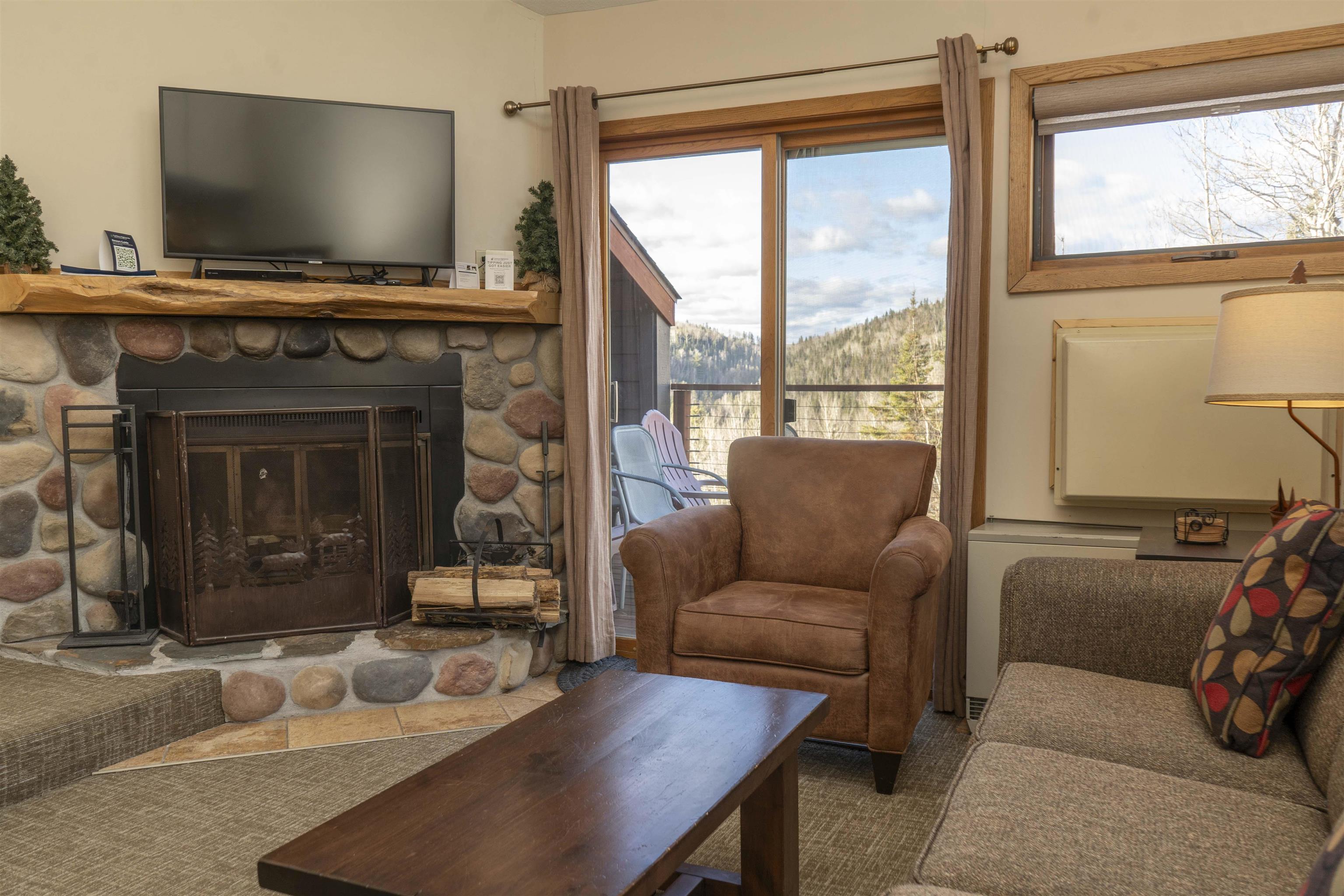 111 Bridge Run Lane, Unit 111 Lutsen, MN 55612 - Photo 9 of 48 Living room featuring a fireplace, radiator, and tile patterned floors