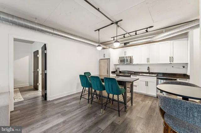 a kitchen with granite countertop a stove a sink and chairs