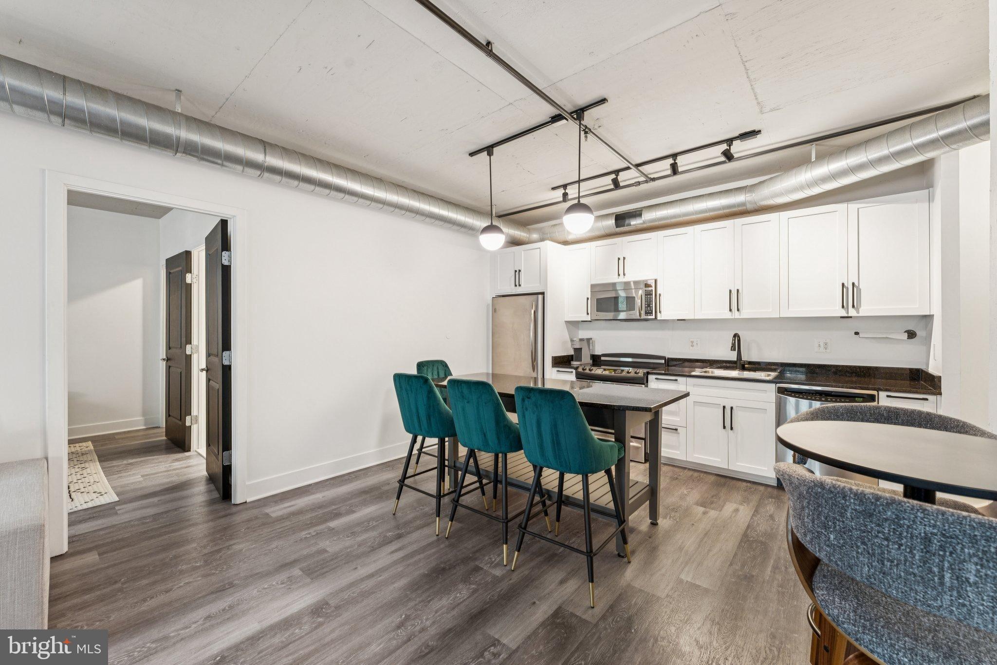 2125 14th Street Northwest, Unit 230 Washington, DC 20009 - Photo 3 of 17 a kitchen with granite countertop a stove a sink and chairs