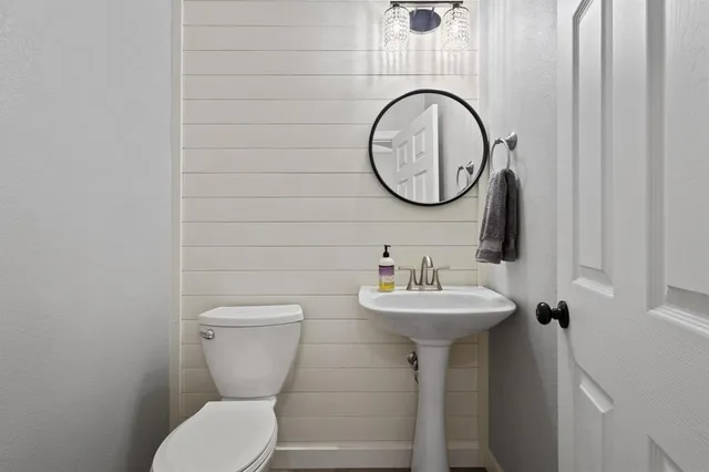 a bathroom with a toilet sink and mirror