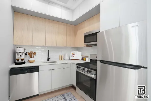 a kitchen with stainless steel appliances a sink cabinets and a refrigerator