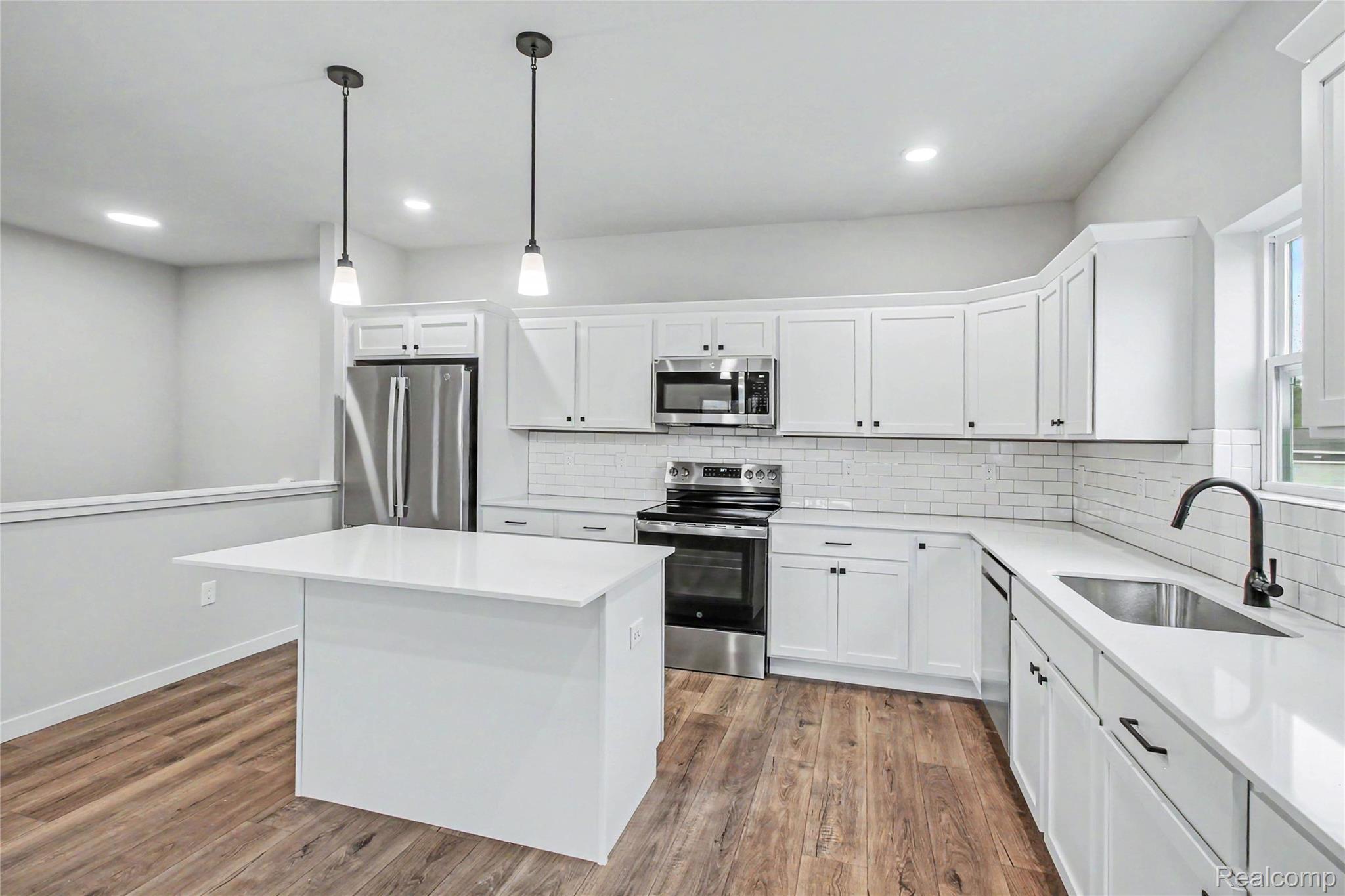 1210 Lockes Street Howell, MI 48843 - Photo 3 of 37 The kitchen includes Quartz counters with subway tile backsplash, large center island with extended edge counter and pendant lighting above. Stainless steel appliances are included!