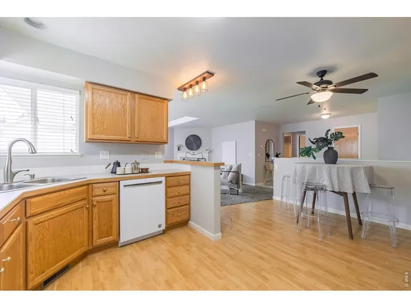 a kitchen with stainless steel appliances granite countertop a sink cabinets and wooden floor