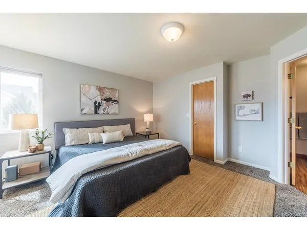 a bedroom with a bed and a painting on the wall